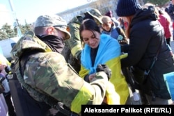 A woman gets an autograph from a Ukrainian soldier.