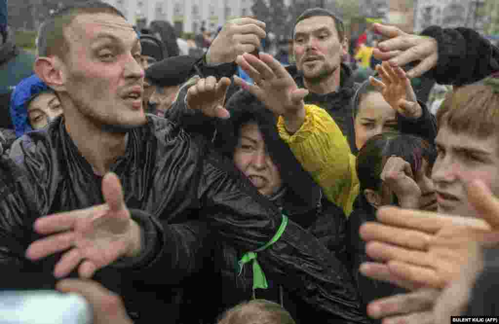 With temperatures expected to fall further, these residents of recently liberated Kherson struggle for supplies at an aid distribution center on November 17.&nbsp;Kyiv says that 10 million Ukrainians were left without power after the latest wave of missile strikes by Russia.