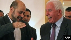 Palestinian Fatah delegation chief Azzam al-Ahmad (right) shakes hands with Hamas deputy leader Mussa Abu Marzuq after a joint press conference in Cairo on April 27.