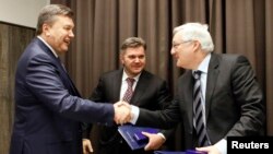 Ukrainian President Viktor Yanukovich (left) shaking hands with Royal Dutch Shell CEO Peter Voser at a January meeting in Davos, Switzerland.