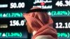 A Saudi man walks at the Tadawul Saudi Stock Exchange, in Riyadh, Saudi Arabia, Monday, June 15, 2015. Saudi Arabia's stock market, valued at $585 billion, opened up to direct foreign investment for the first time Monday, as the kingdom seeks an economic 