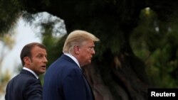 French President Emmanuel Macron welcomes U.S. President Donald Trump at the G7 summit, August 24, 2019.