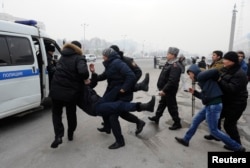 Полицейские задерживают участников акции протеста после девальвации тенге. Алматы, 15 февраля 2014 года.