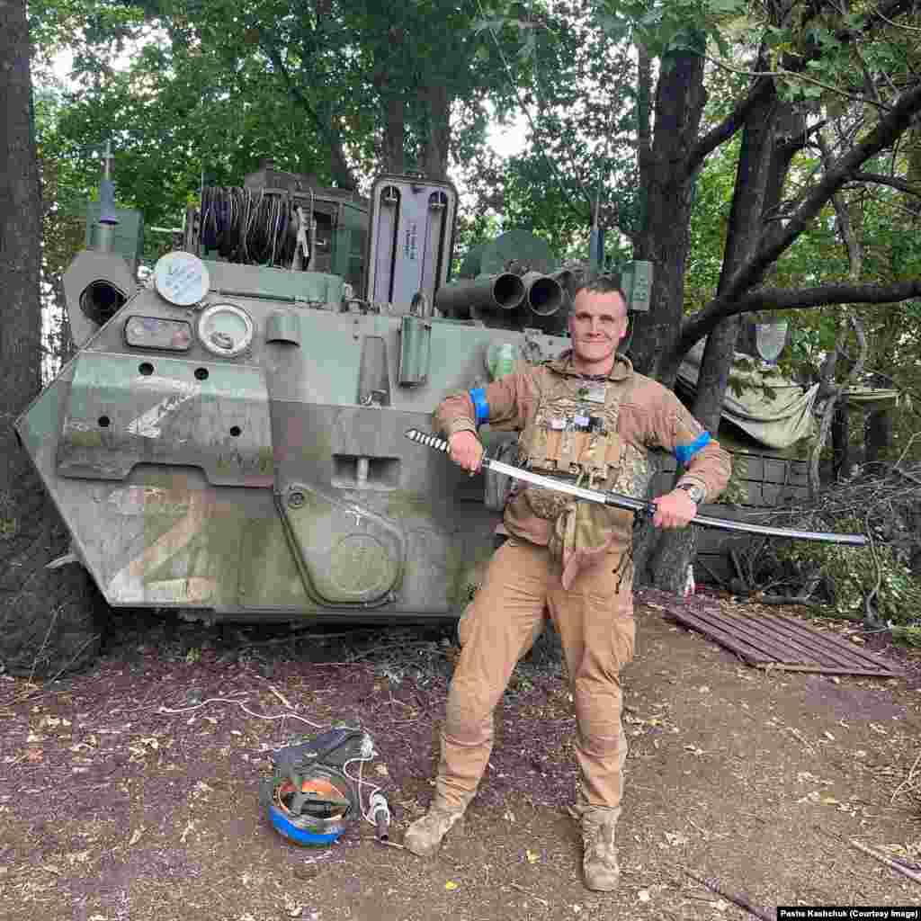 Pasha Kashchuk poses with a captured Russian vehicle and samurai sword in the Kharkiv region.&nbsp;