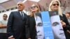 British director Sally Potter (right), U.S. actress Julianne Moore (center), and the director of the 79th Venice International Film Festival, Alberto Barbera, hold a poster showing jailed Iranian director Jafar Panahi.