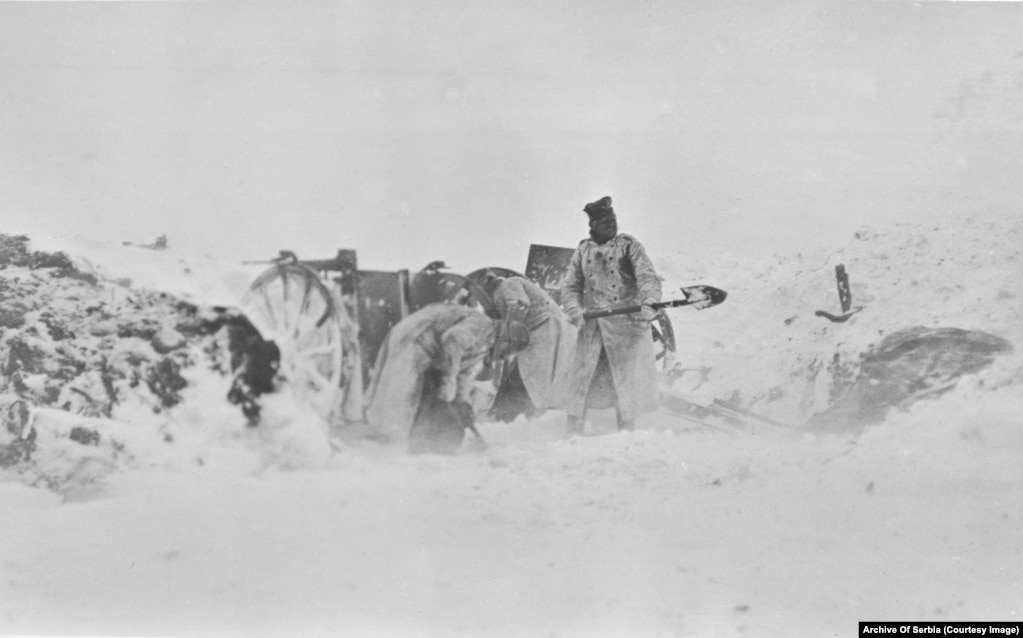 Ushtarë të paidentifikuar duke pastruar borën nga një pozicion gjatë një stuhie dimri.