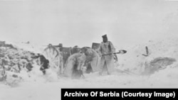 Неидентифицирани войници почистват снега от позиция по време на зимна буря.