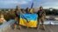 Ukrainian soldiers hold a flag on a rooftop in Kupyansk on September 10. Kupyansk is a transportation hub in eastern Ukraine and strategically important for supplying Russian troops in the Donbas region.