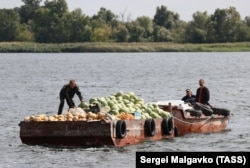 Люди на Херсонщині використовували човни, щоб перевозити фрукти та овочі на інший берег Дніпра, вересень 2022 року