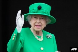 Regina Elisabeta a II-a a Marii Britanii face cu mâna mulțimii de la balconul Palatului Buckingham la sfârșitul sărbătorii consacrate jubileului său de platină de la Londra, pe 5 iunie 2022.