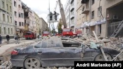 Pompierii ucraineni printre clădirile puternic avariate după cel mai recent atac cu rachete rusești în centrul orașului Harkov, 6 septembrie 2022