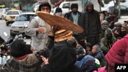 آرشیف، شماری از خانواده‌های نیازمند حین دریافت کمک نان خشک در شهر کابل.