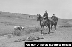 Oficerët bullgarë duke shikuar trupin e një ushtari osman.