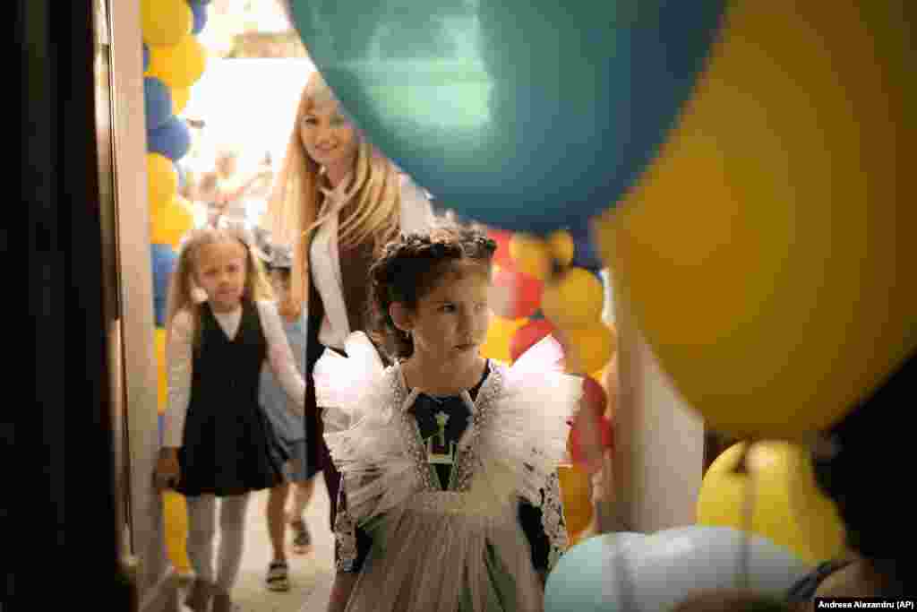 A Ukrainian refugee girl enters the Ienachita Vacarescu Elementary School after a ceremony marking the beginning of the school year in Bucharest.