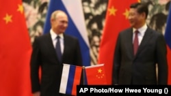 Flamuri rus dhe ai kinez, teksa në sfond shihen lideri i Rusisë, Vladimir Putin, dhe ai i Kinës, Xi Jinping. Fotografi ilustruese. 