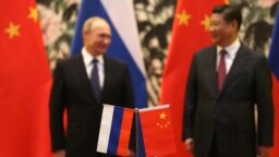 Flamujt e Rusisë dhe Kinës teksa në sfond të fotografisë shihen dy udhëheqësit e këtyre shteteve të cilët kanë marrë pjesë në një samit në Pekin më 2014. 