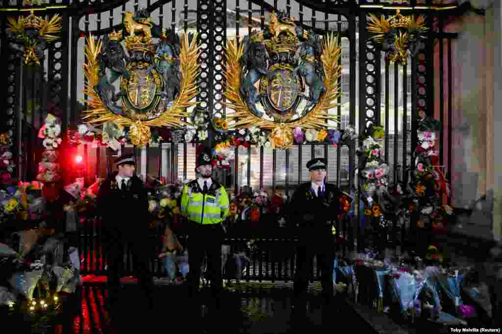 În noaptea de după anunțul morții Reginei, mii de oameni au venit la porțile Palatului Buckingham, păzite de polițiști.