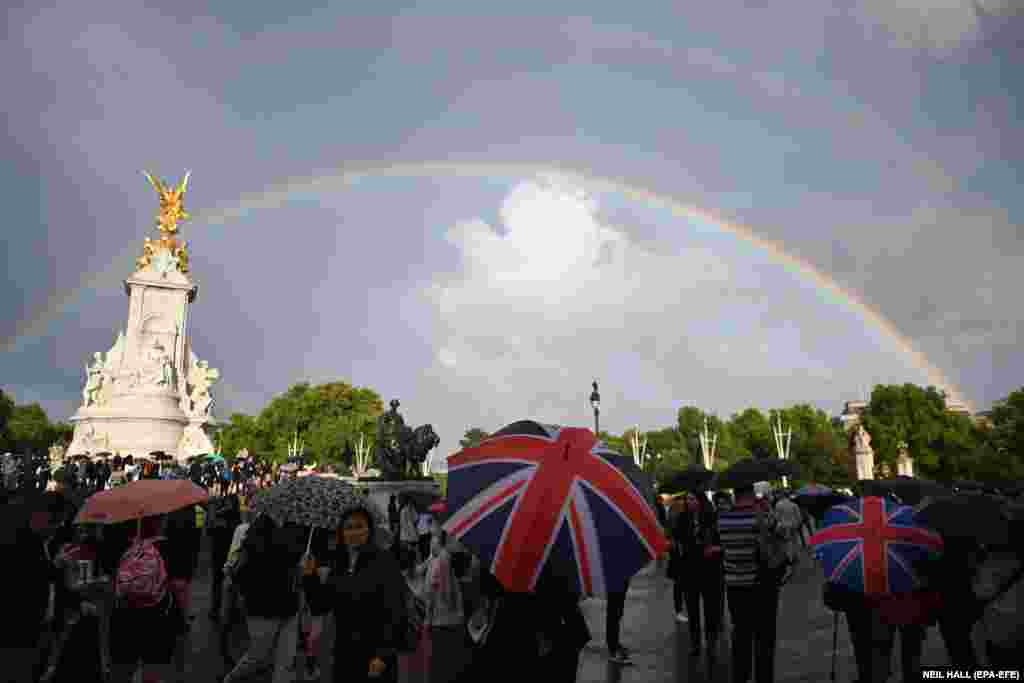 Un curcubeu apare deasupra Memorialului Reginei Victoria în timp ce oamenii se adună în fața Palatului Buckingham din Londra, Marea Britanie, pe 8 septembrie 2022. Foto:&nbsp;EPA-EFE/Neil Hall