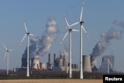 Ветряки на фоне угольной электростанции в Германии