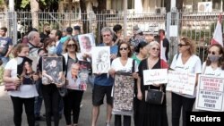 Članovi porodica nekih od žrtava eksplozije u bejrutskoj luci u avgustu 2020. nose njihove slike i transparente tokom protesta ispred Palate pravde u Bejrutu, Liban, 7. septembar 2022.