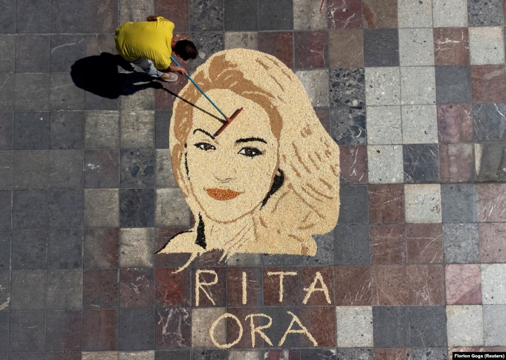 Në kryeqytetin shqiptar, Tiranë, artisti kosovar Alkent Pozhegu duke punuar në krijimin e portretit të këngëtares britanike të lindur në Prishtinë, Rita Ora, të bërë me grurë, oriz, fara luledielli, misër dhe thjerrëza.
