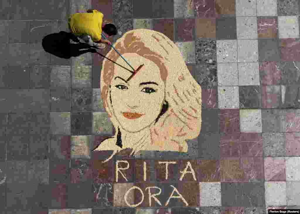 In the Albanian capital, Tirana, Kosovar artist Alkent Pozhegu works on the final touches to a portrait of Pristina-born British singer Rita Ora made with wheat, rice, sunflower seeds, corn, and lentils.