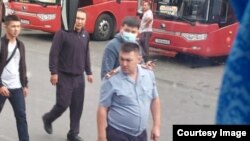 Сотрудник полиции и человек в штатском на снимке, снятом из салона автобуса