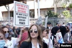 Članovi porodica nekih od žrtava eksplozije u bejrutskoj luci u avgustu 2020. nose njihove slike i transparente tokom protesta ispred Palate pravde u Bejrutu, Liban, 7. septembar 2022.