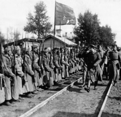 Red Army commander Leon Trotsky salutes soldiers near today’s St. Petersburg in 1919.