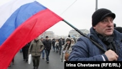 A man carrying a Russian flag walks to a demonstration on Moscow's Bolotnaya Square on December 10.