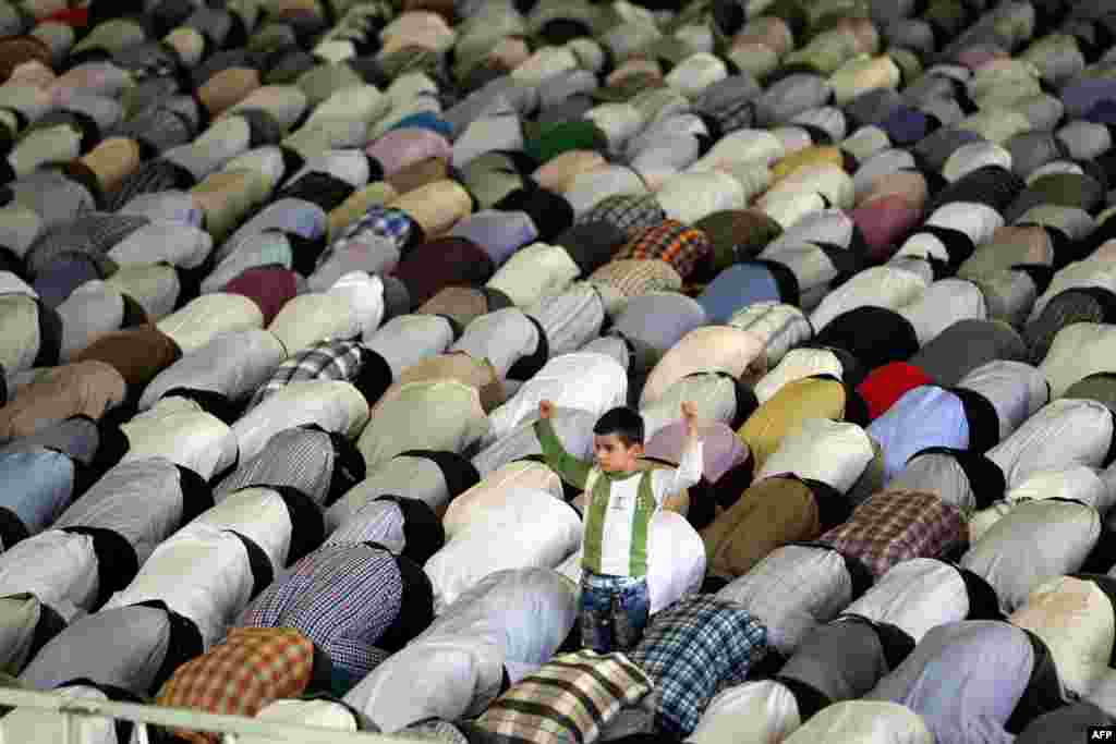 A young boy stands among Shi'ite Muslim worshippers attending the weekly Friday Prayers during the Muslim fasting month of Ramadan at Tehran University. (AFP/Atta Kenare)