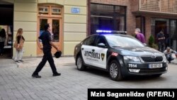 Сотрудник грузинской полиции направляется к служебному автомобилю в Тбилиси. 28 сентября 2016 года.