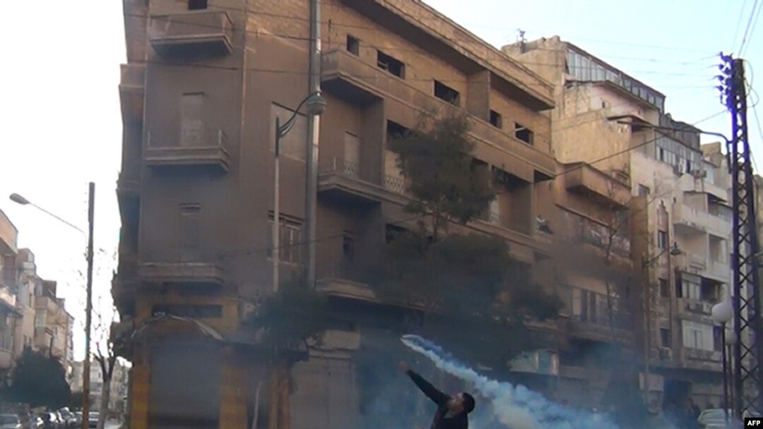 Suriyanın Homs şəhərində etiraz aksiyası iştirakçısı qaz balonunu qaytarıb polisin özünə atır, 27 dekabr 2011