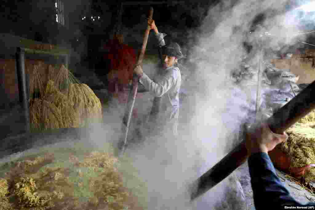 Работнікі мяшаюць воўну ў чане на фарбавальным заводзе ў Кабуле, Аўганістан