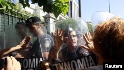Escorts of people with disabilities try to break through a police formation outside parliament during a rally against new austerity measures in Athens in late September.