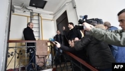 Militanții pentru drepturile omului Aleksandr Podrabinek (stînga) and Lev Ponomariov (al doilea din stînga) vorbesc presei în fața apartamentului lui Zoia Svetova în timp ce acesta e percheziționat de anchetatori, Moscova, 28 februarie 2017