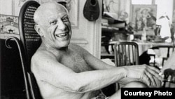 France -- Pablo Picasso laughing in his favorite rocking chair, 1957