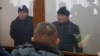 Murager Alimuly (right) and Kaster Musahanuly are seen in the defendants' cage at their trial on January 6 in Zaysan.