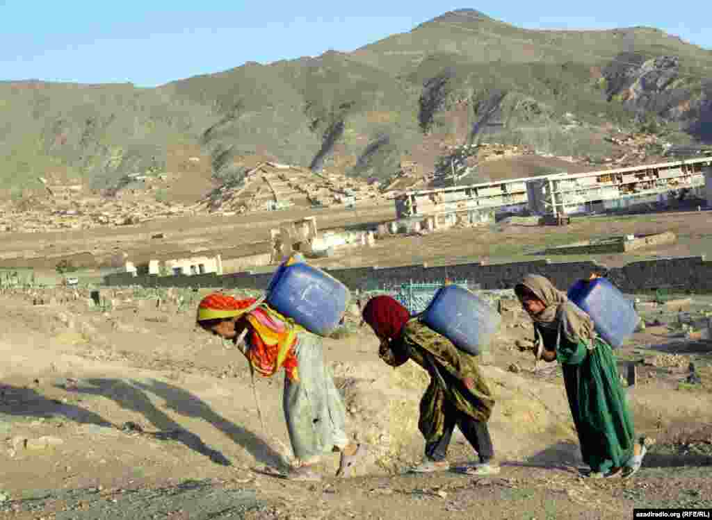 Girls carrying water. Photo by RFE/RL's Radio Free Afghanistan. - One in four Afghan children aged seven to 14 is reported to be involved in some form of work. 