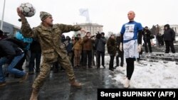 A Ukrainian serviceman throws a ball at a mannequin depicting Russian President Vladimir Putin dressed in a soccer uniform during a "Stop Putin. Stop war" rally in January.