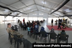 Afghan refugees listen to a fire safety lecture in a US military base in Kosovo in October 2021.