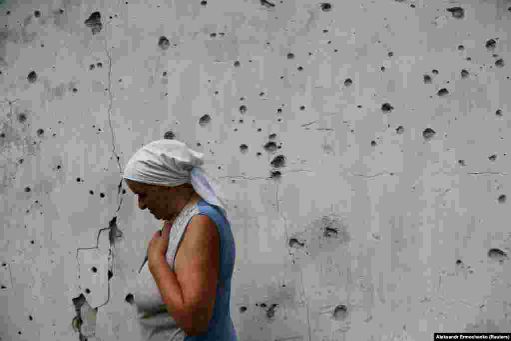 Local resident Katerina Izvekova, 77, shows her house that was damaged during fighting between Russia-backed militants and Ukrainian armed forces near the separation line in the rebel-controlled village of Veseloye on July 27. (Reuters/Alexander Ermochenko)