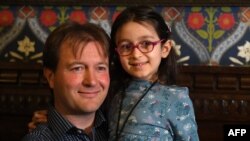 Richard Ratcliffe, husband of British-Iranian aid worker Nazanin Zaghari-Ratcliffe jailed in Tehran since 2016, holds his daughter Gabriella during a news conference in London, on October 11, 2019. - The five-year-old daughter of a British-Iranian woman j