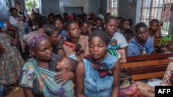 Disa nëna duke pritur që fëmijët e tyre të sëmurë të marrin vaksina kundër malaries në një spital në Malavi. Prill 2019.