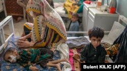 آرشیف- یک مادر در کنار بستر کودکش که مصاب به سوء تغذیه است در شفاخانه کندهار نشسته است