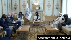 Taliban officials Mullah Abdul Ghani Baradar (center) and others met with British High Representative for Afghan Transition Simon Gass (third left) on October 5. 