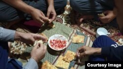 Afghan pilots break bread together at the sanatorium outside of Dushanbe where they have been housed since fleeing Afghanistan on August 15.