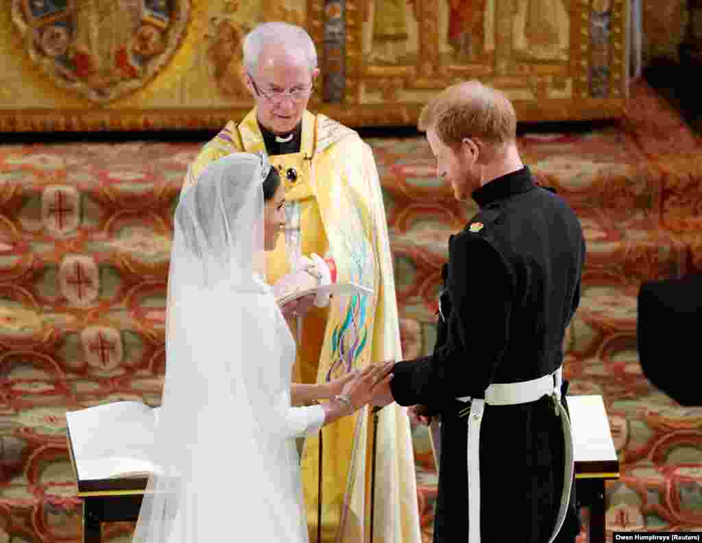 Принц Гарри и Меган Маркл во время церемонии бракосочетания, которую проводит архиепископ Кентерберийский Джастин Уэлби. Архиепископ Кентерберийский &ndash; духовный глава Церкви Англии в Соединенном Королевстве, а также духовный лидер Англиканского сообщества во всем мире.