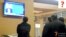 Aşgabadyň aeroportunda telewizora tomaşa edýän ýaşaýjylar.