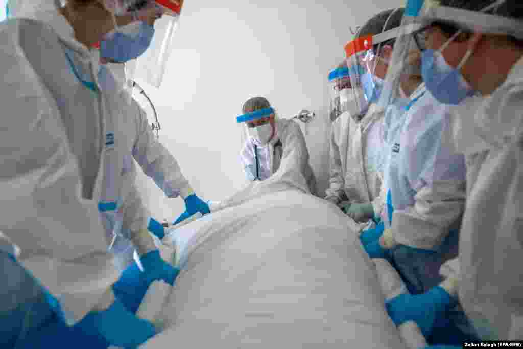 Doctors and nurses wearing protective gear turn over a COVID-19 patient in the intensive care unit of the Szent Laszlo Hospital in Budapest. Hungary ranks in the top five in the world in per-capita deaths from the coronavirus.